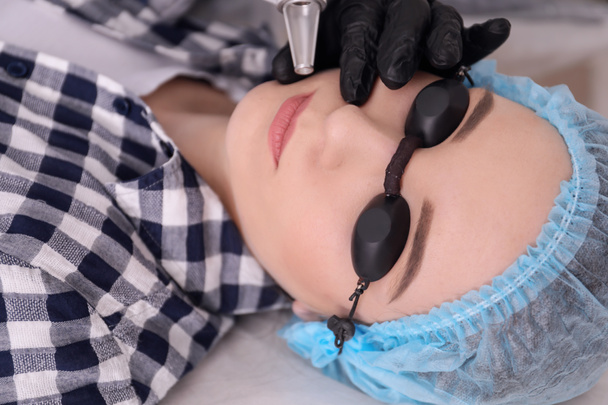 Cosmetologo con laser di rimozione del tatuaggio paziente e professionale nel salone
 - Foto, immagini