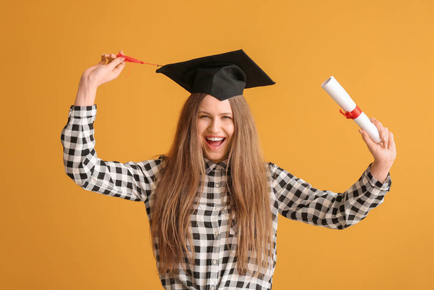 Felice studentessa laureata con diploma su sfondo di colore - Foto, immagini