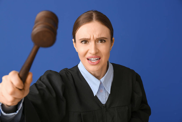 Angry female judge on color background - Fotoğraf, Görsel