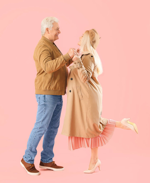 Portrait of happy elderly couple on color background - Foto, afbeelding