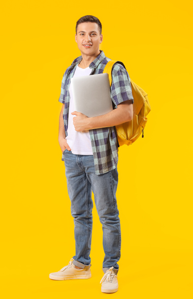 Male student with laptop on color background - Photo, Image