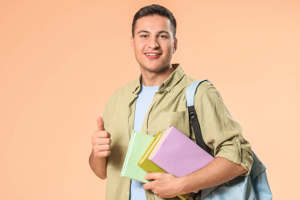 Retrato de un estudiante masculino mostrando el pulgar hacia arriba en el fondo de color
 - Foto, imagen