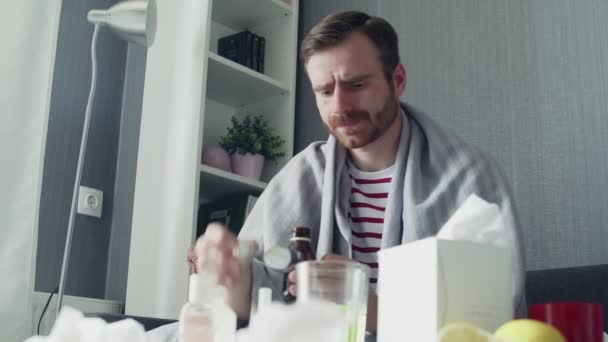 Kranker Mann schüttet Medikamente oder fiebersenkenden Sirup ein, um es zu löffeln und zu trinken - Filmmaterial, Video