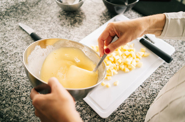 Mujer prepara los ingredientes para hacer un pastel de esponja
  - Foto, Imagen