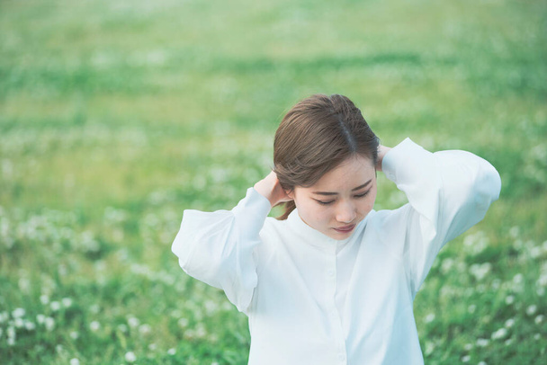 Asian young woman showing a relaxed expression on the meadow - Photo, Image