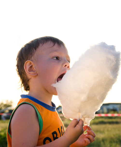 若い男の子の綿キャンディ棒を食べる - 写真・画像