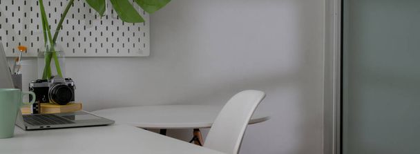 Gehakt schot van minimale home office interieur design met witte werktafel met stoel en witte cirkel salontafel  - Foto, afbeelding