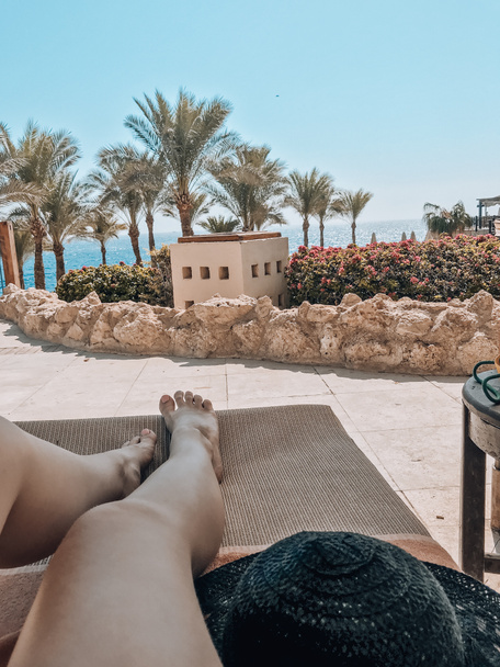 Open zicht van een ligstoel naar de zee en bloemen in Egypte. - Foto, afbeelding
