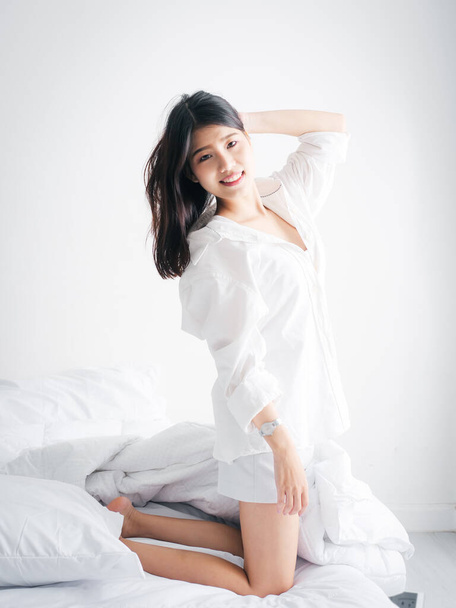 Happy Asian woman relaxing on bed, lifestyle concept. - Foto, imagen