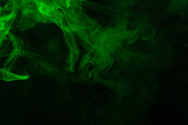 Green steam on a black background. Copy space. - Foto, Imagen