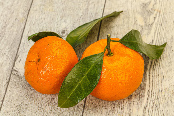 Ripe sweet tasty tangerine with green leaves - Фото, изображение