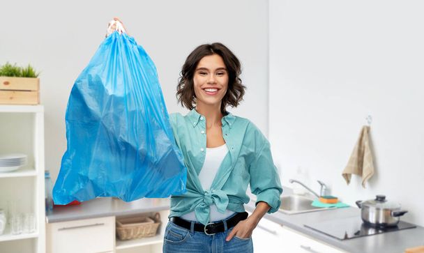 smiling woman holding plastic trash bag with waste - Photo, image