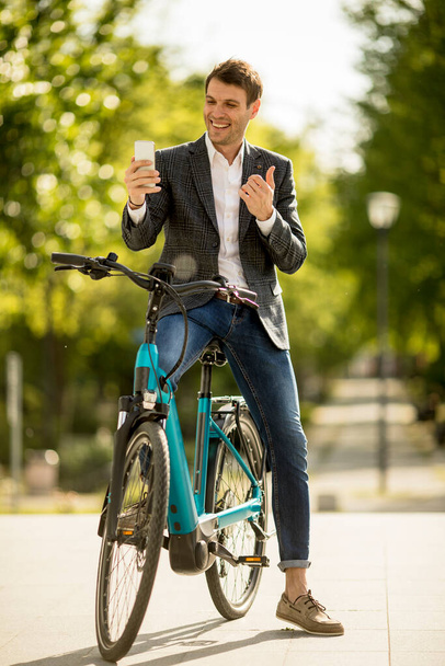 Handosmer Jungunternehmer auf dem E-Bike macht Selfie-Foto mit Handy - Foto, Bild