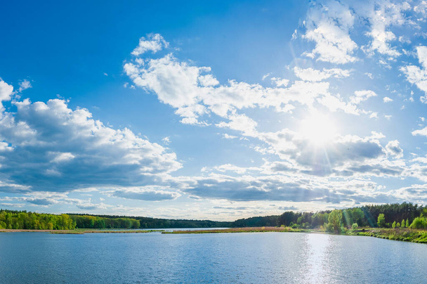 Maisema panoraama kaunis sininen suuri järvi ja taivas pilvet vihreä metsä rannalla. Pond 15, tunnetaan nimellä 5 glade. Kiova, Ukraina
 - Valokuva, kuva