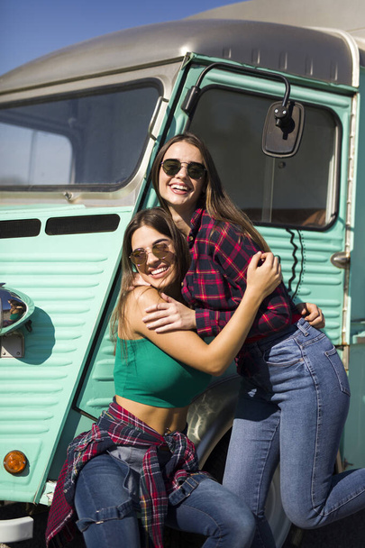 Due belle donne sorridenti dal minivan vintage - Foto, immagini