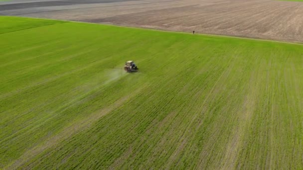Fertilización por pulverización tractora en el campo con productos químicos en cultivos de trigo nad cebada en el borde del campo
 - Imágenes, Vídeo