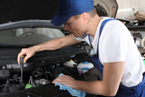 Professional auto mechanic fixing modern car in service center - 写真・画像