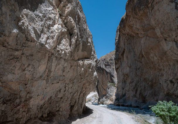 Berge Zentralasiens. eine schmale Straße zwischen Bergen. schnelle Flüsse und spärliche Vegetation. Es gibt keine Menschen. - Foto, Bild