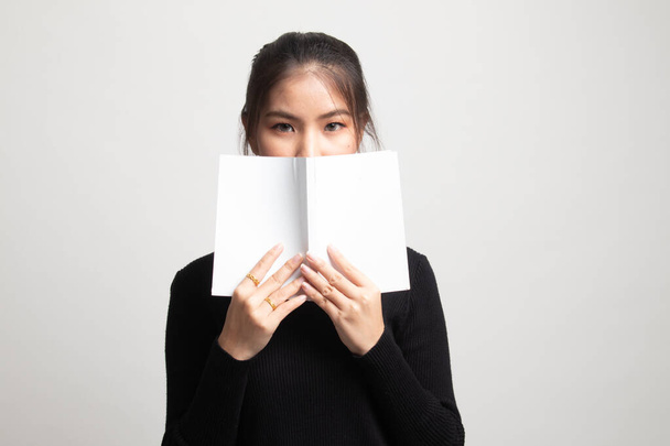 Joven asiática mujer con un libro cubrir su cara en blanco fondo
 - Foto, imagen