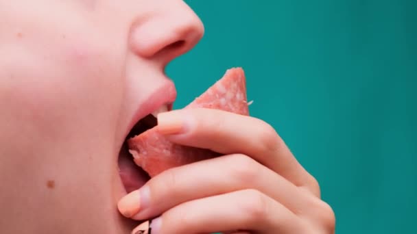 Close up of a woman biting a sausage on a green screen. Unhealthy diet and diet concept - Footage, Video