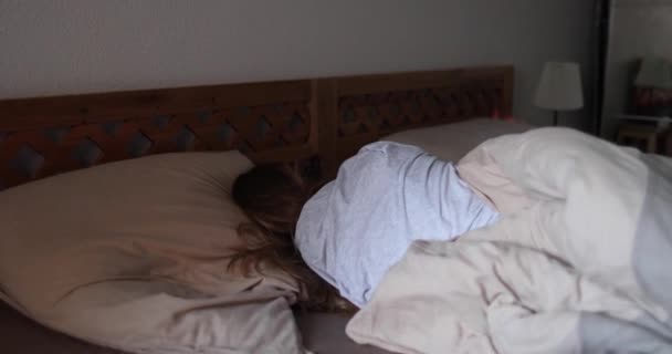 Meisje met lang blond haar slaapt op een houten bed  - Video