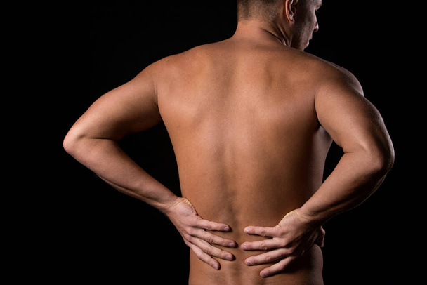 Kerl hat Schmerzen im Rücken wegen schwarzem Hinterteil - Foto, Bild