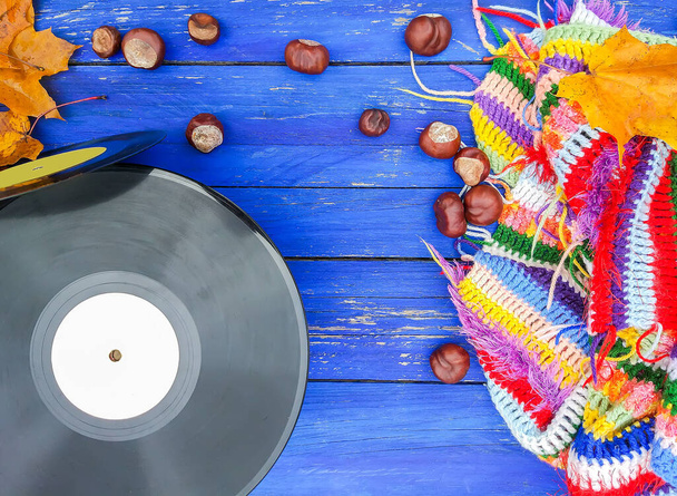 高齢者の木製の背景にヴィンテージビニールレコード明るい手作りのかぎ針編みの再生、栗と秋の葉 - 写真・画像