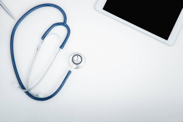 Stetoskop ve dijital tablet bilgisayarın en üst görüntüsü. Teknoloji ve tıbbi konsept. - Fotoğraf, Görsel