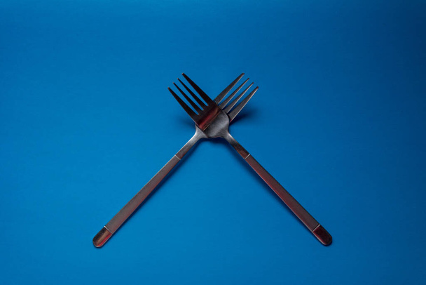 iron fork on a blue background - 写真・画像