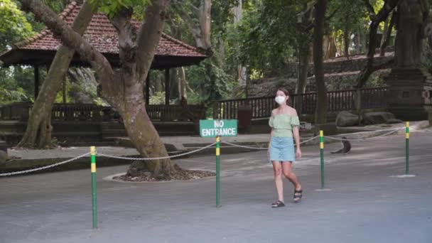 Ritratto di giovane ragazza che cammina vicino alla famosa destinazione turistica Ubud Monkey Forest a Bali, Indonesia. Concetto: Salute, Vuoto Destinazione Turistica, Le persone rimangono in casa durante il Coronavirus
. - Filmati, video