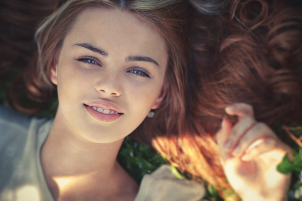 Young woman lying on grass portrait - 写真・画像
