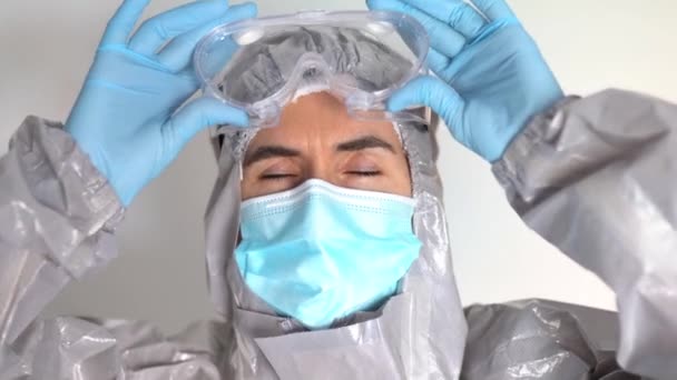 Γιατρός σε Μέσα Ατομικής Προστασίας Βάζοντας τα γυαλιά ασφαλείας - Πλάνα, βίντεο