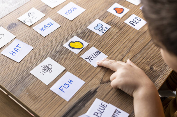 Niño jugando con cartas de palabras e imágenes. Es hora de aprender. Concepto educativo
. - Foto, imagen
