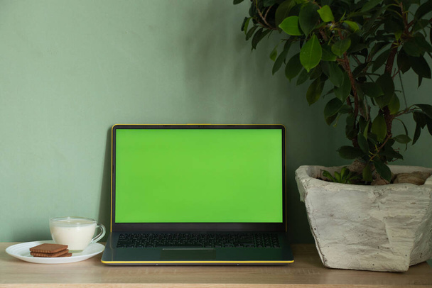 ordinateur portable avec yaourt à écran vert avec des cookies sur une table dans une chambre à la maison
 - Photo, image