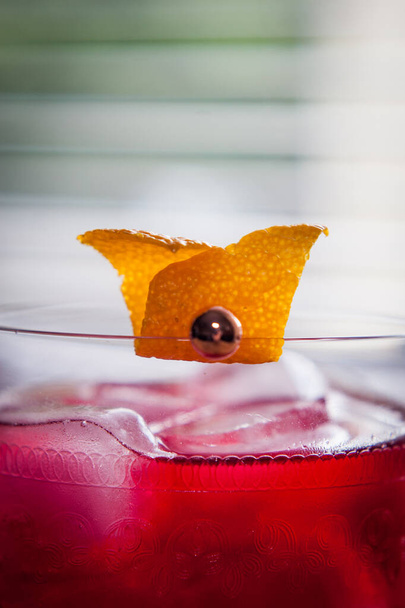 Červený negroni koktejl u okna s klasickou pomerančovou slupkou - Fotografie, Obrázek