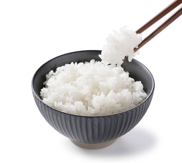 Scooping rice with chopsticks on a white background - Foto, afbeelding
