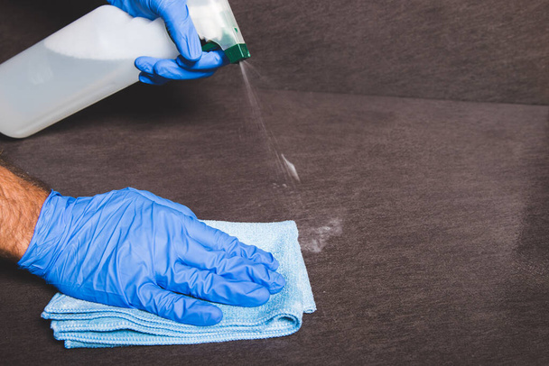 the act of cleaning a surface with gloves and a rag - 写真・画像