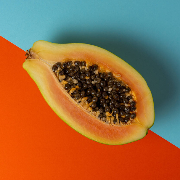 Creative tropical layout with papaya on colorful vivid paper. Minimal abstract summer concept. Flat lay. - Fotoğraf, Görsel