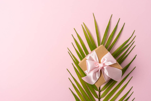 Creative layout made with flowers and palm leaf on pink backdrop. Spring minimal concept. - 写真・画像