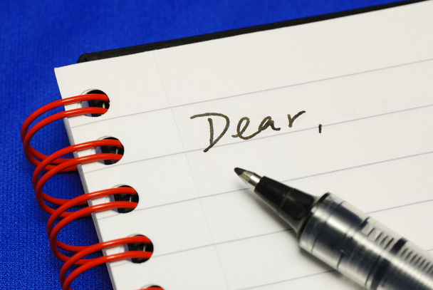 La palabra Querido con un bolígrafo conceptos de escribir una carta aislada en azul
 - Foto, imagen