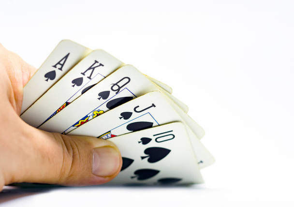 hazardní hráč odhalí královskou flush in spades. Hazard a štěstí. Rozhodnutí a rizika. Izolováno na bílém pozadí - Fotografie, Obrázek