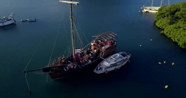 4K-Aufnahmen der Luftaufnahme der Martinique Marina Bay mit dem alten Piratenboot im klaren blauen Wasser, Karibische Inseln - Filmmaterial, Video