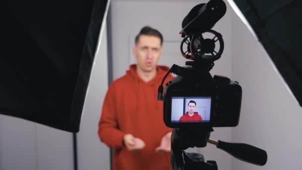 Giovane blogger uomo riprese nuovo video vlog con fotocamera professionale a casa
 - Filmati, video