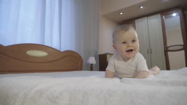 Cute baby with blue eyes lying in the bedroom - Footage, Video