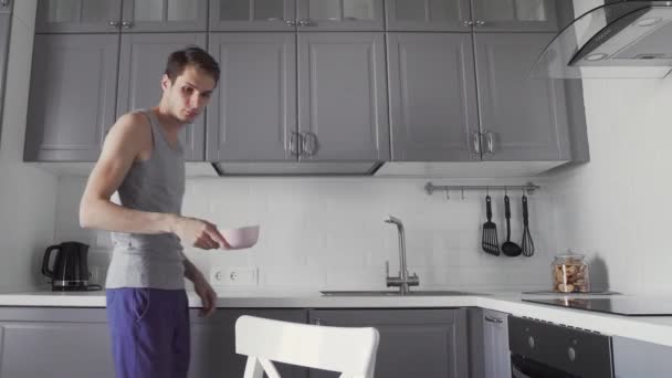 Young man having breakfast at the kitchen. - Video, Çekim