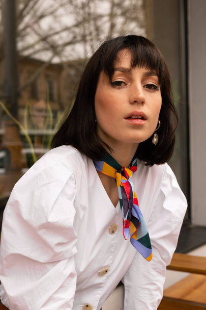 Retrato de mujer joven en blusa blanca con una bufanda colorida
 - Foto, imagen