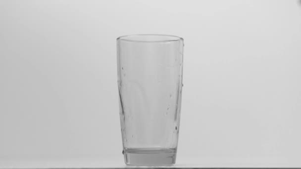 průzračná průsvitná voda proudí shora do skla - Záběry, video
