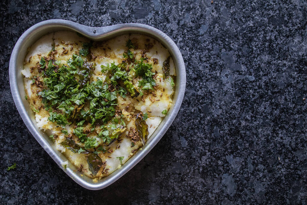 gujarati delicacy dhokla prepared in a heart shaped bowl with gray granite background - Photo, Image