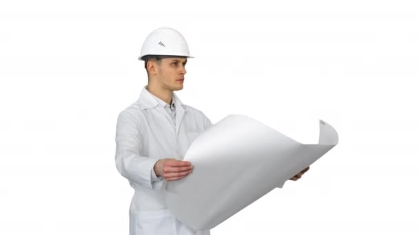 Handsome engineer, architect, builder, businessman, wearing a white helmet holding a project in his hand, looking at the object and dancing on white background. - Felvétel, videó