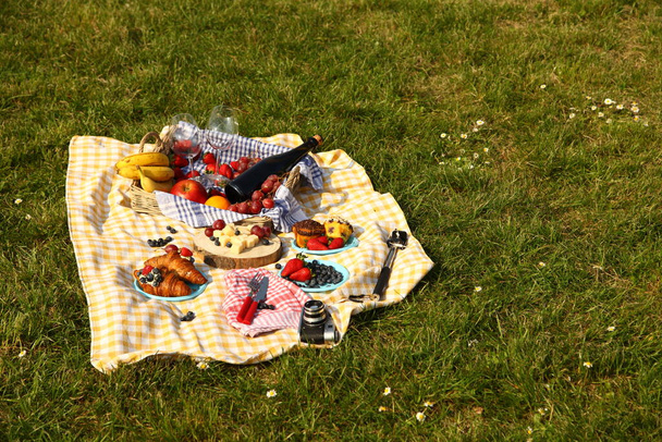 piknik v létě s produkty, sendvič, salát, ovoce, nápoj a klobouk na zelené trávě textury pozadí horní pohled mockup - Fotografie, Obrázek